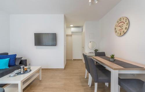 a dining room and living room with a table and a clock at Apartments Hana in Funtana in Funtana