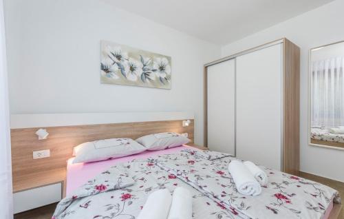 a bedroom with a bed with a pink and white comforter at Apartments Hana in Funtana in Funtana