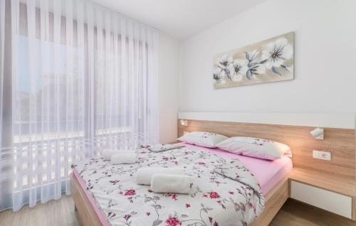 a white bedroom with a bed with flowers on it at Apartments Hana in Funtana in Funtana