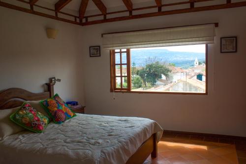 1 dormitorio con cama y ventana grande en Posada Portal de la Villa en Villa de Leyva