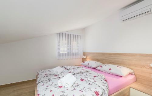 a bedroom with a pink bed with white sheets and pillows at Apartments Hana in Funtana in Funtana