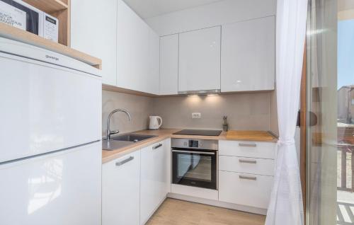 a kitchen with white cabinets and a sink at Apartments Hana in Funtana in Funtana