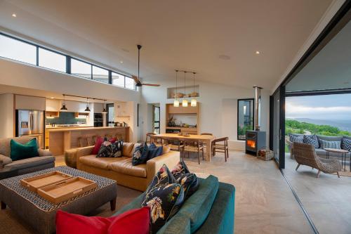 a living room with two couches and a table at Alkira Lodge in Brenton-on-Sea
