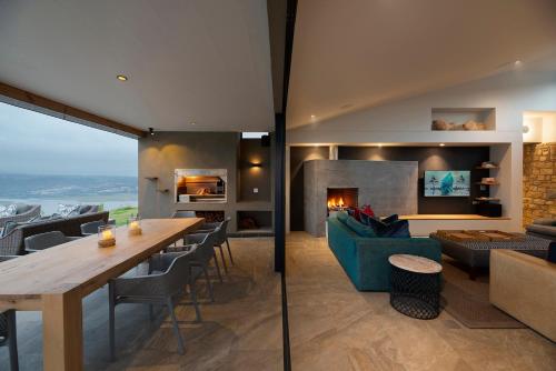a living room with a table and a fireplace at Alkira Lodge in Brenton-on-Sea