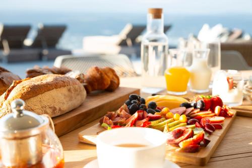 a table with a breakfast of fruit and bread and juice at Alkira Lodge in Brenton-on-Sea
