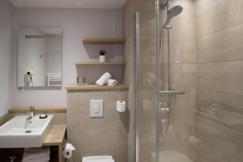 a bathroom with a shower and a toilet and a sink at The Originals Boutique, Hôtel des Marins, Saint-Malo (Inter-Hotel) in Saint Malo