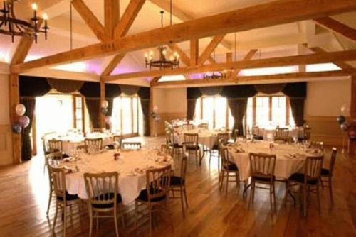 a banquet hall with tables and chairs with white table cloth at Newtown House Hotel in South Hayling