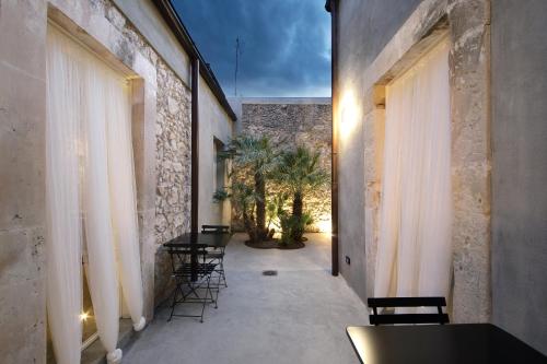 a corridor of a building with chairs and tables at ISONZO SUITES in Siracusa
