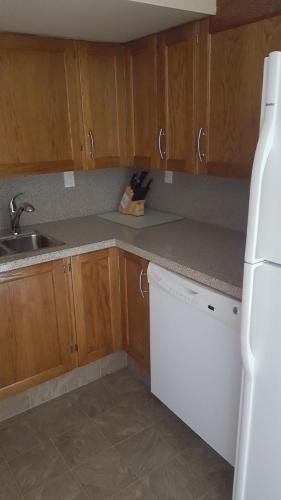 a kitchen with wooden cabinets and a white refrigerator at Window Hill in St. Albert