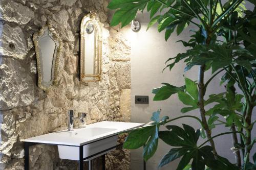 a bathroom with a white sink and a plant at ISONZO SUITES in Syracuse