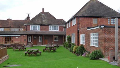 a courtyard with picnic tables in a brick building at Newtown House Hotel in South Hayling
