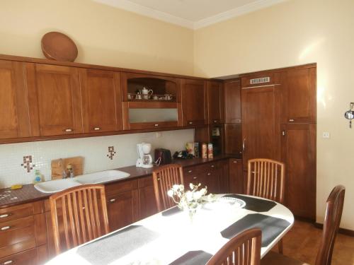 a kitchen with wooden cabinets and a table with chairs at The Pirate's Mansion in Nafplio