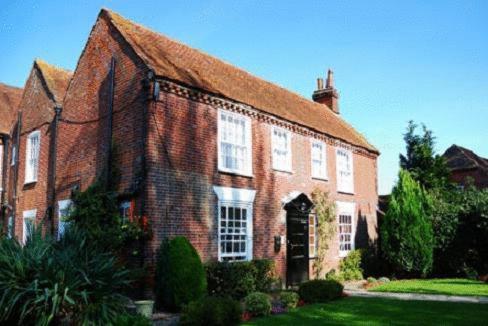 a large red brick house with a roof at Newtown House Hotel in South Hayling