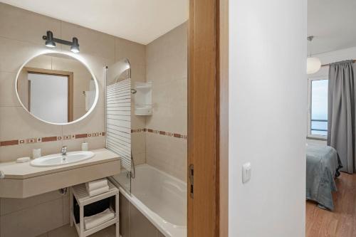 a bathroom with a sink and a mirror and a tub at Garajau III by An Island Apart in Caniço
