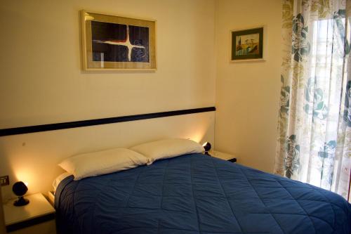 1 dormitorio con 1 cama azul y 2 almohadas en Appartamento SOYUS 10, en Lido di Jesolo
