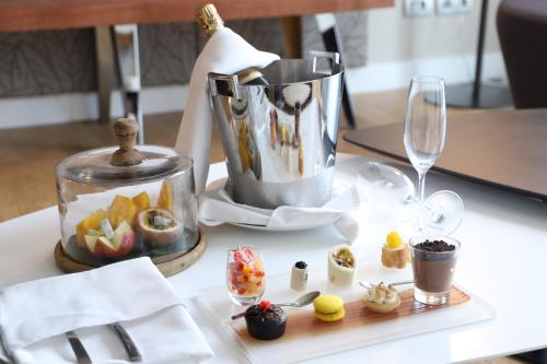 a table with a tea pot and a plate of desserts at Pullman Abidjan in Abidjan