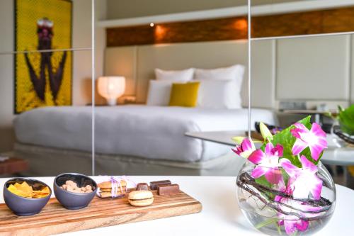 a hotel room with a bed and a table with a tray of food at Pullman Abidjan in Abidjan