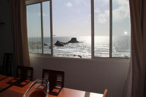 a dining room with a view of the ocean at Apartamento Sto Estevão in Zambujeira do Mar