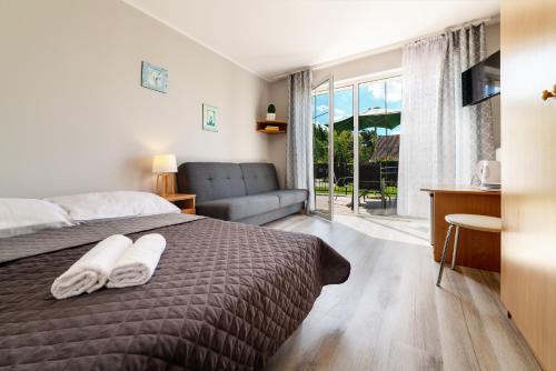 a bedroom with a bed and a couch and a window at D.W. KRYSTYNA in Dębki