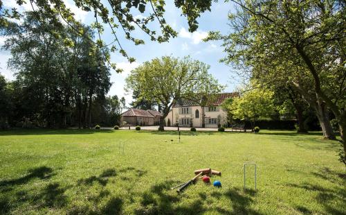 a large yard with a house and some balls at Holly Lodge Boutique B&B in Thursford