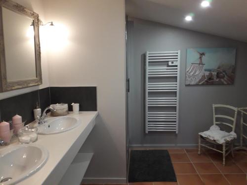 La salle de bains est pourvue de 2 lavabos, d'un miroir et d'une chaise. dans l'établissement Le petit Bouchou, à Six-Fours-les-Plages