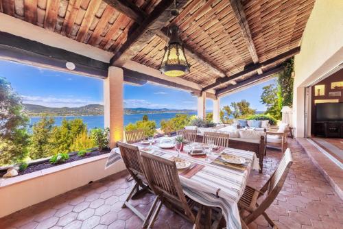 uma sala de jantar exterior com uma mesa e vistas para o oceano em Villa with Magic view of Bay of Saint Tropez em Saint-Tropez