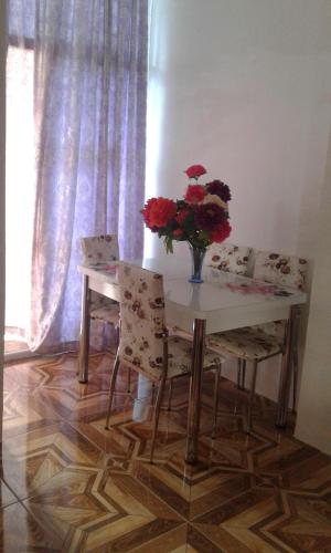 a table and chairs with a vase of flowers on it at Hotel Georgia in Gonio