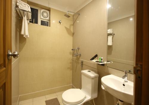 a bathroom with a toilet and a sink at Laimar Suites in Cochin