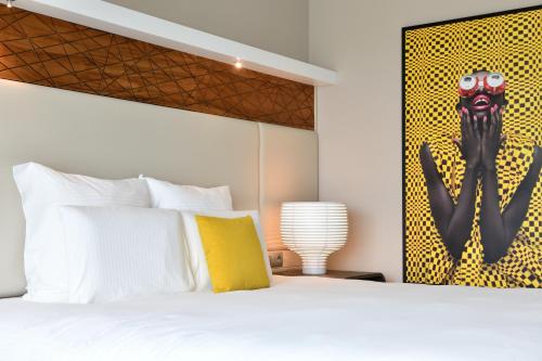 a bedroom with a bed and a painting of a skeleton at Pullman Abidjan in Abidjan