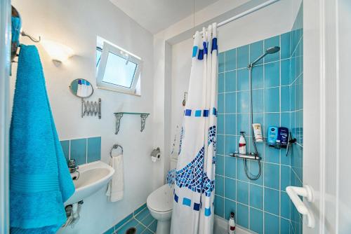 un bagno blu e bianco con doccia e lavandino di Villa Thea a Vrouchas