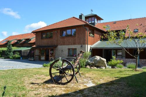 a wooden house with a largemill in front of it at Ekofarma Horní Chrášťany in Lhenice