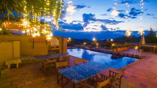 a pool at night with tables and chairs at Hotel Terra Barichara in Barichara