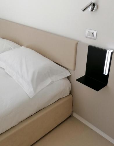 a bedroom with a bed and a tv on the wall at BARI 102 in Bari