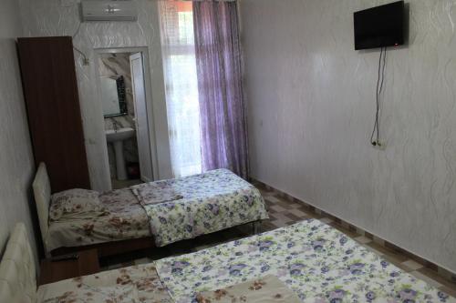 a small bedroom with two beds and a mirror at Hotel Georgia in Gonio