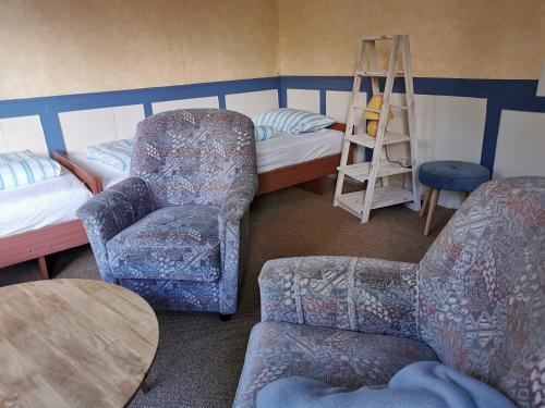a room with a bed and a chair and a ladder at Ferienhof Ehlers in Hülsede