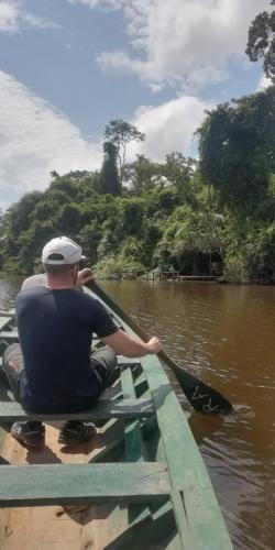 a man is rowing a boat on a river at Ecolucerna Lodge Tambopata in Puerto Maldonado