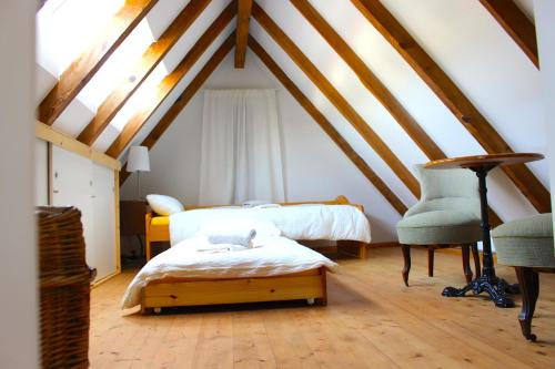 a attic room with two beds and a chair at Atelierhaus Beckmann in Gengenbach