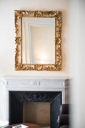 a mirror over a fireplace in a living room at Hotel Rua Frati 48 in San Francesco in Modena