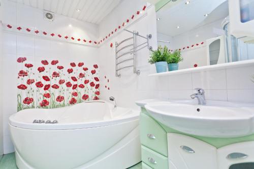Baño blanco con flores rojas en la pared en KvartiraSvobodna - Apartments Kievskaya, en Moscú