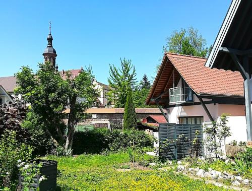 a house with a tower in the middle of a yard at Atelierhaus Beckmann in Gengenbach