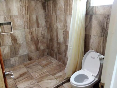 La salle de bains est pourvue d'une douche et de toilettes. dans l'établissement Hotel Palapa Palace Inn, à Tuxtla Gutiérrez