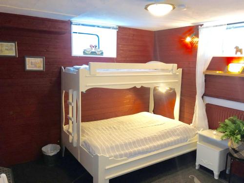 a bunk bed in a room with red walls at Prinsgården B&B rum stugor in Mora