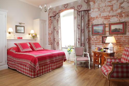 een slaapkamer met een rood bed en een bakstenen muur bij Hotel Dwór Kościuszko in Krakau