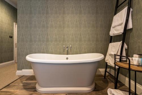 a bathroom with a white bath tub in a room at Carbis Bay and Spa Hotel in St Ives