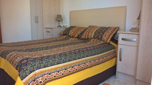 ein Schlafzimmer mit einem Bett mit einer Decke darauf in der Unterkunft Apartaments La Cala de Mijas Atico in Mijas Costa