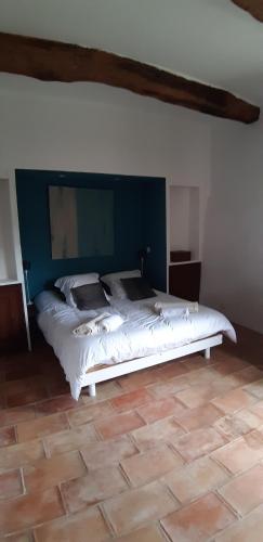um quarto com uma cama branca e uma parede azul em La vieille porte em Tourrettes-sur-Loup