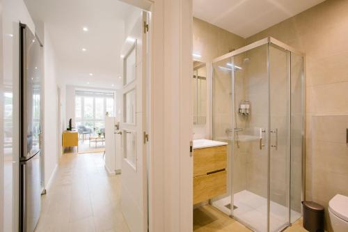 a bathroom with a glass shower and a sink at PRIM 26 in Donostia-San Sebastián