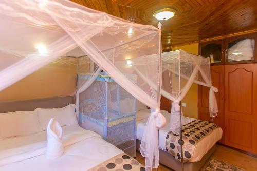 a bedroom with two beds and a canopy bed at Zarita Boutique Hotel in Nairobi