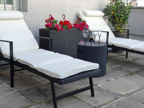 three wicker chairs sitting on a patio with flowers at Apartment New Belgrade Home in Belgrade