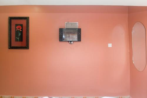 an orange wall with a tv on it at Zarita Boutique Hotel in Nairobi